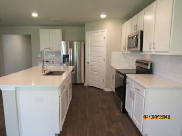 a kitchen with a sink a counter top space stainless steel appliances and cabinets