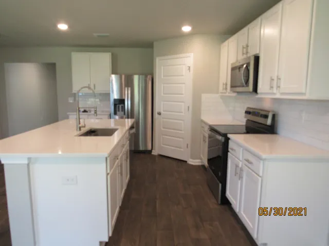 a kitchen with a sink a counter top space stainless steel appliances and cabinets