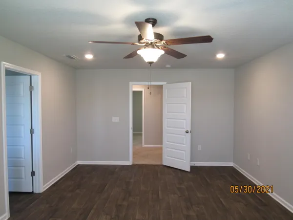 wooden floor in an empty room with a fan