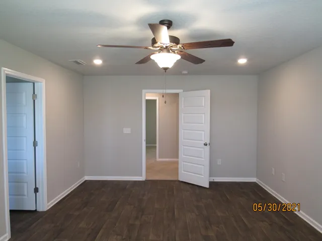 wooden floor in an empty room with a fan