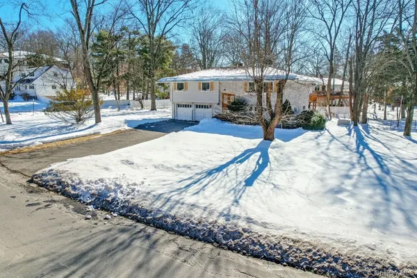 a view of a backyard with snow on the road