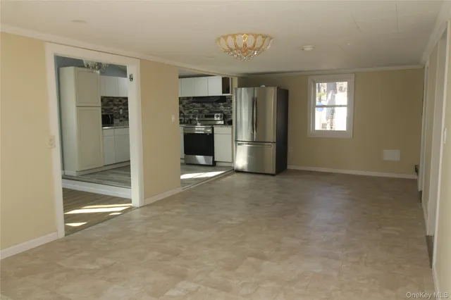 a view of kitchen with refrigerator and window