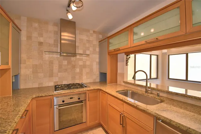 a bathroom with a granite countertop sink and a large mirror