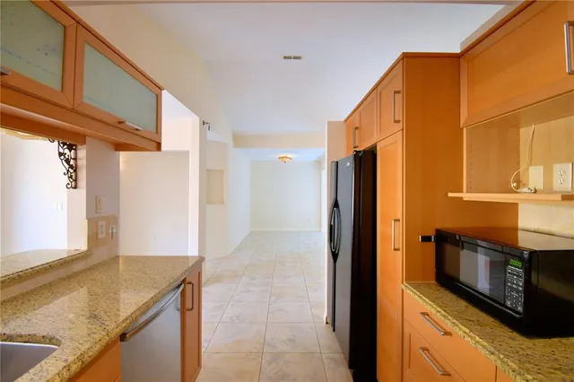 a view of an empty room with a chandelier fan