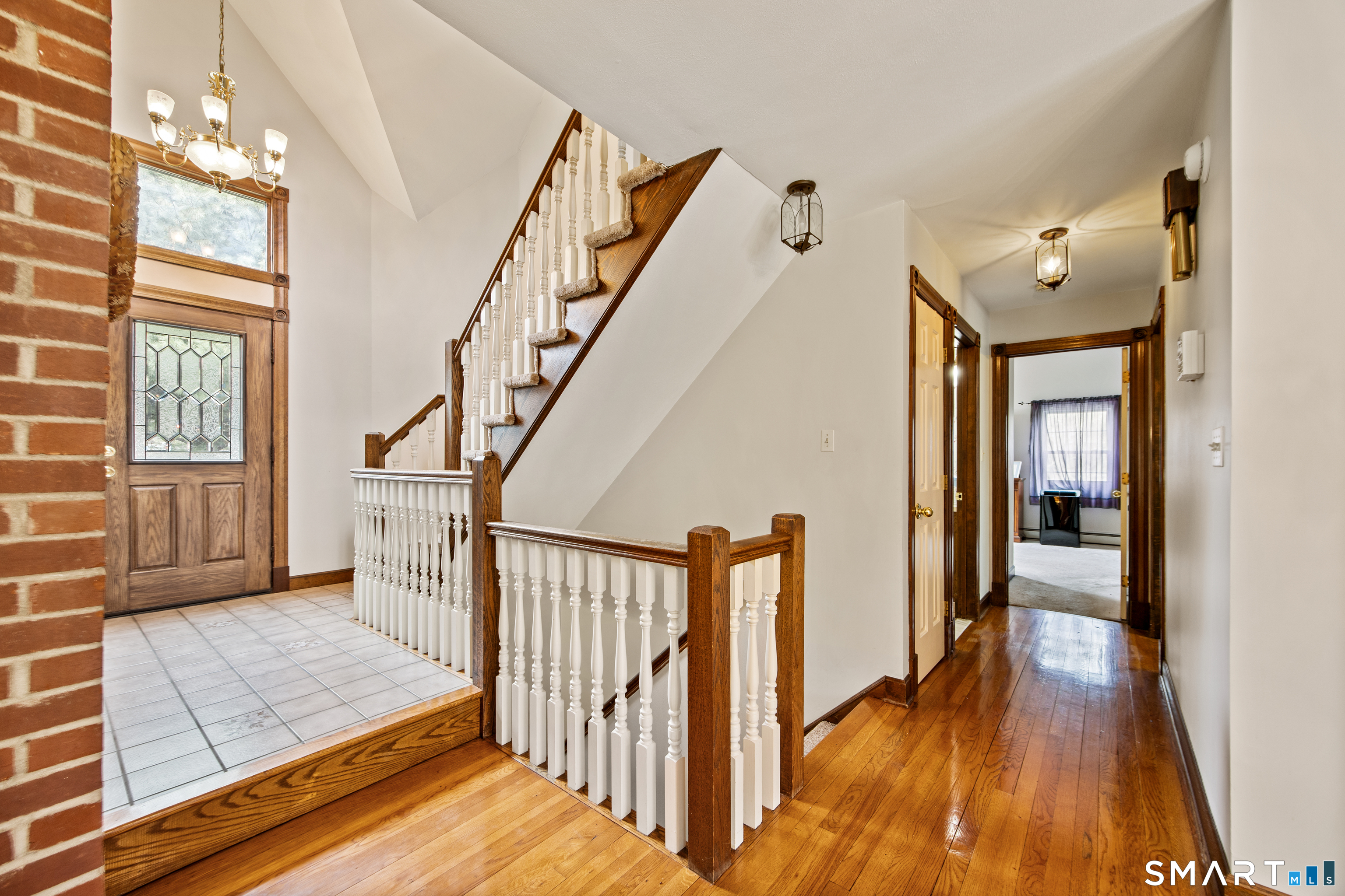 105 Quaker Farms Road Southbury, CT 06488 - Photo 5 of 40 a view of a hallway with wooden floor and staircase