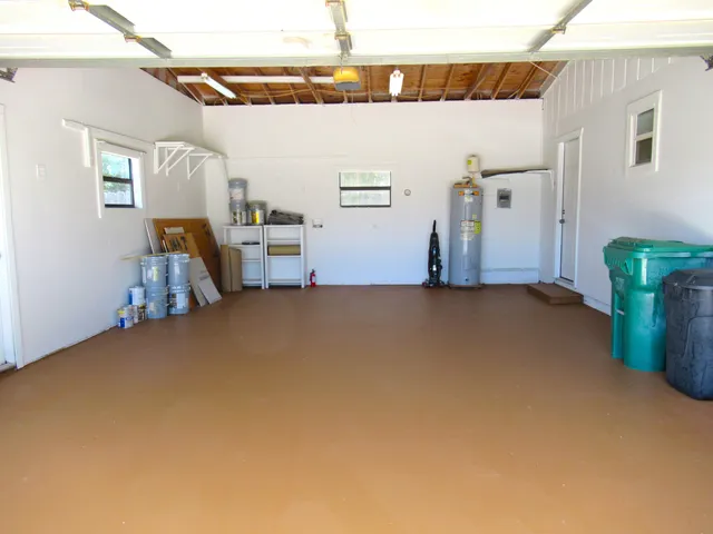a backyard of a house with a large tree and wooden fence