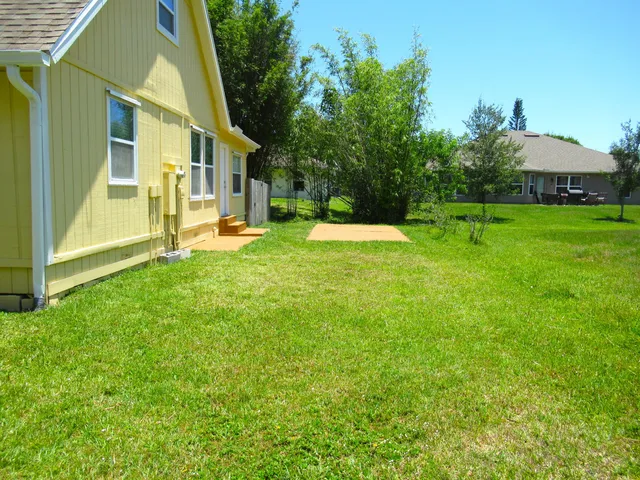 a view of an empty room with stairs and a chandelier fan