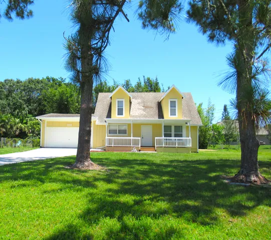 a front view of a house with a yard and a garage