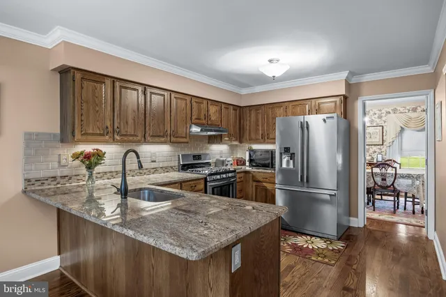 a kitchen with granite countertop a refrigerator and a sink