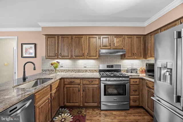 a kitchen with stainless steel appliances granite countertop a stove sink and cabinets