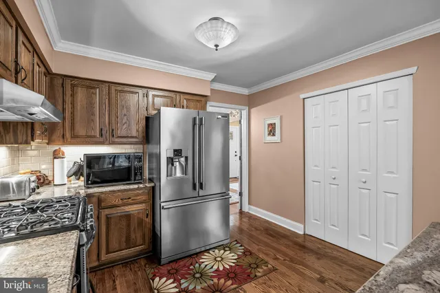 a kitchen with stainless steel appliances granite countertop a refrigerator stove and sink
