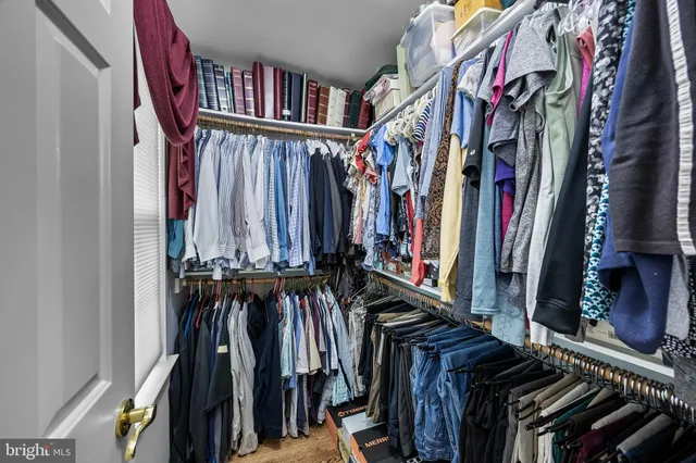 a view of walk in closet with clothes and shoes