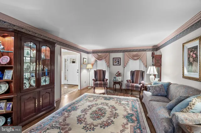 a living room with furniture large window and wooden floor