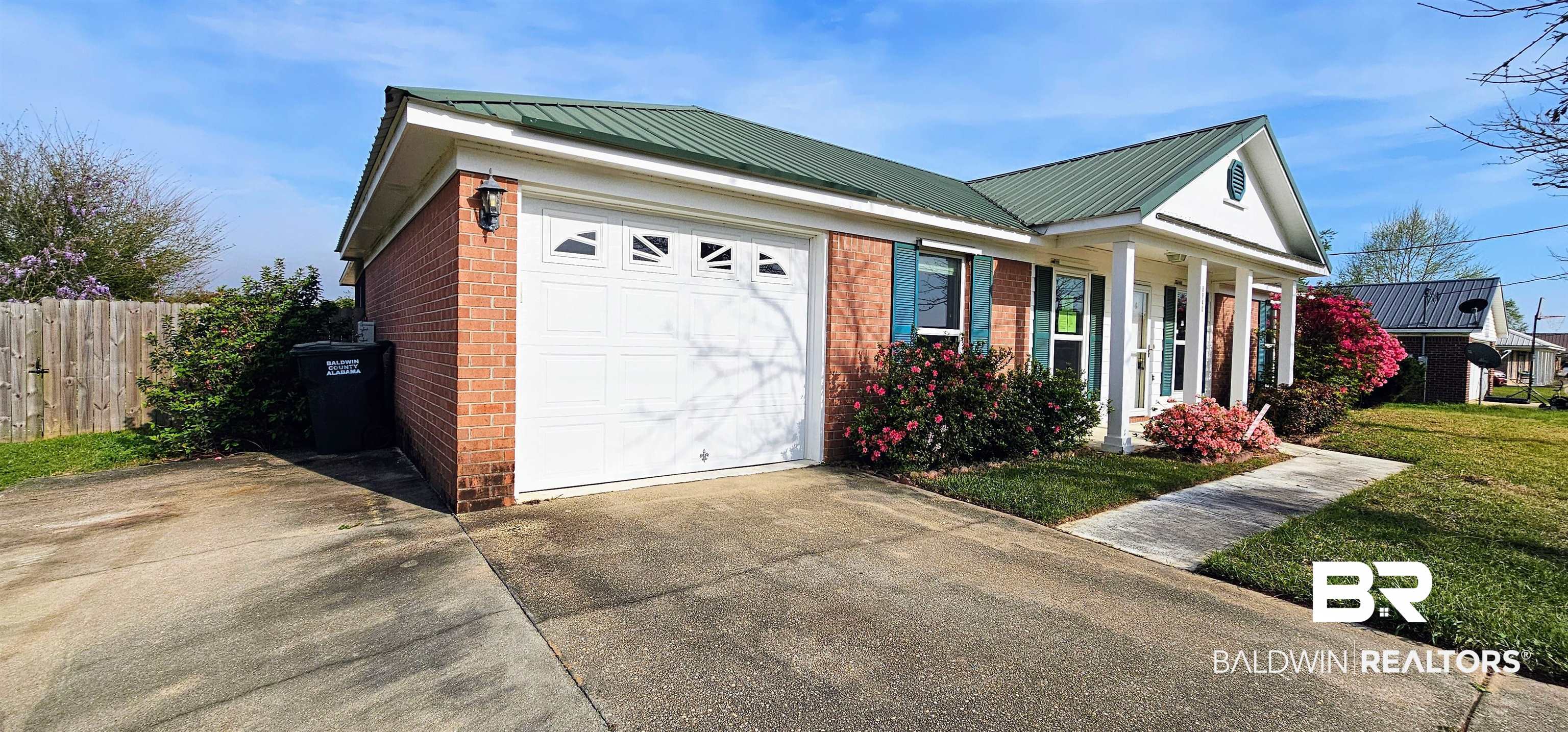 8940 Shannon's Mill Road Foley, AL 36535 - Photo 2 of 35 View of side of home featuring brick siding, an attached garage, driveway, a metal roof, and a porch