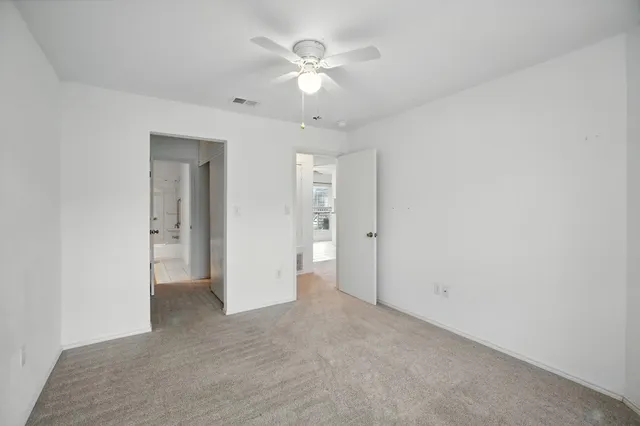 an empty room with fan and a ceiling fan