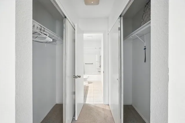 a view of a hallway with wooden floor and closet