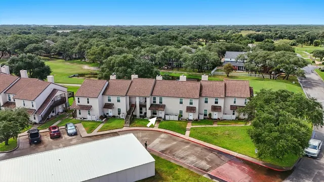an aerial view of multiple houses with a yard
