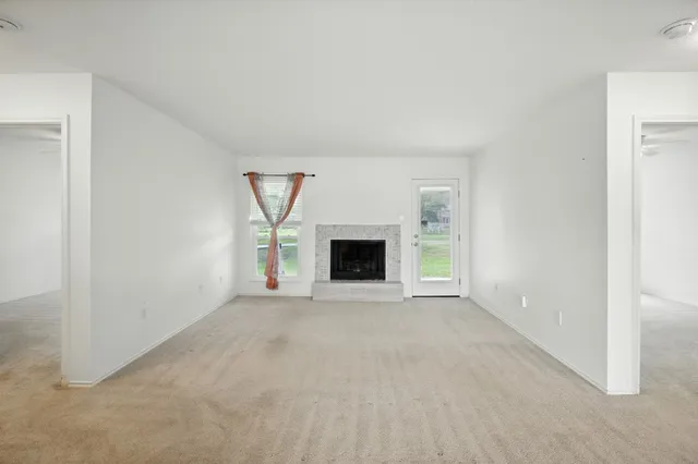 an empty room with a fireplace and a window