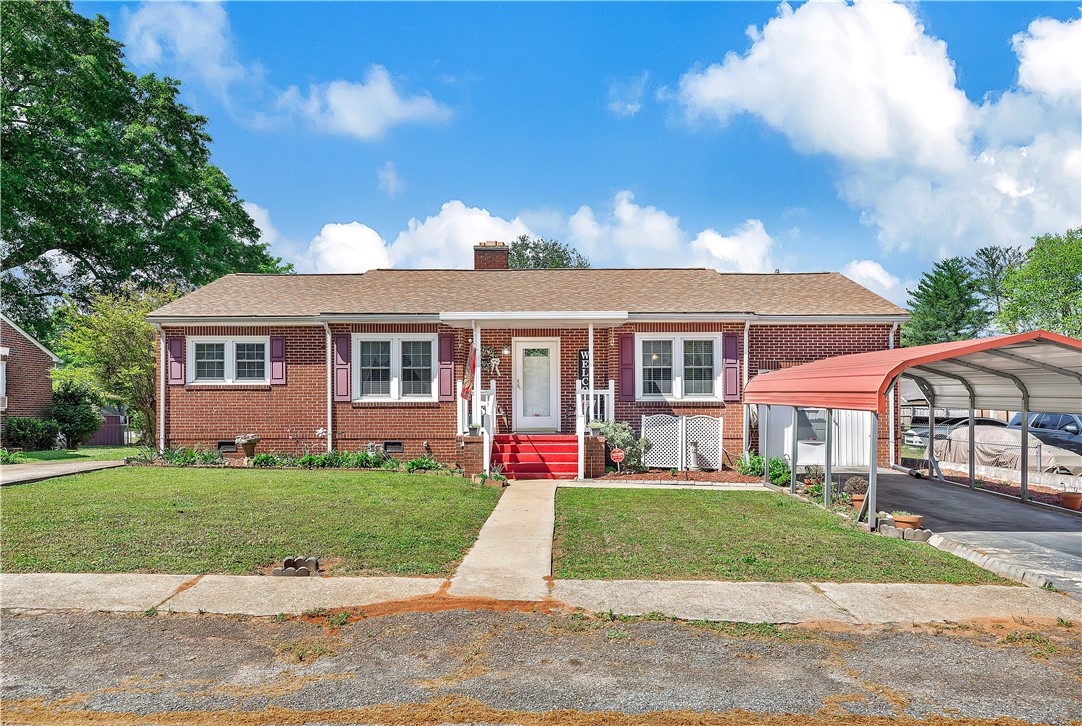 This classic brick residence features a welcoming front porch and a convenient carport.