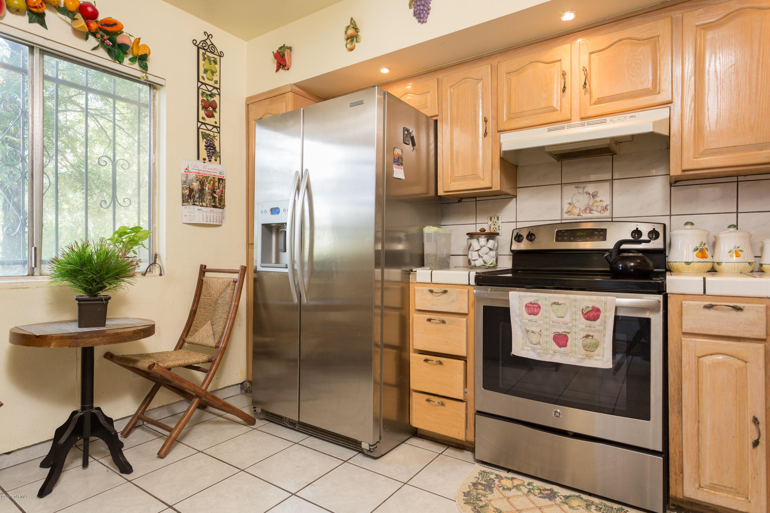 3546 South Mission Road, Unit B Tucson, AZ 85713 - Photo 2 of 15 a kitchen with stainless steel appliances granite countertop a stove a refrigerator and a microwave