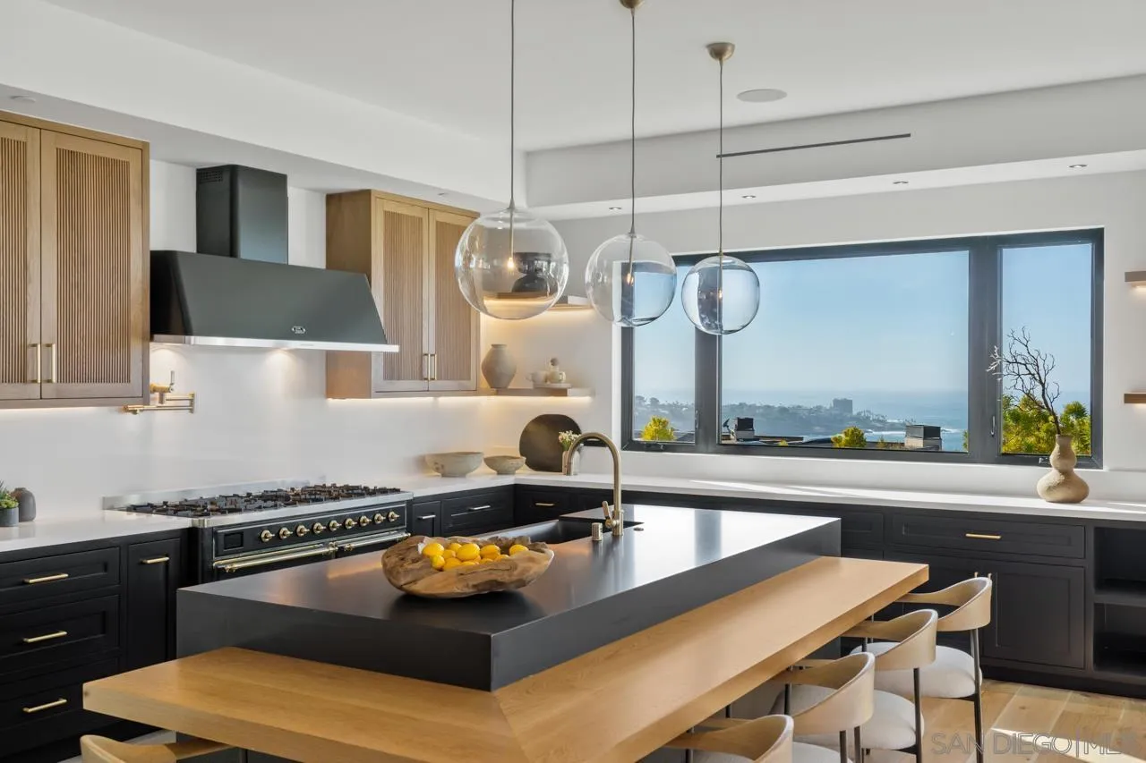 8433 Prestwick Drive La Jolla, CA 92037 - Photo 45 of 74 a kitchen with a sink a counter and chairs in it