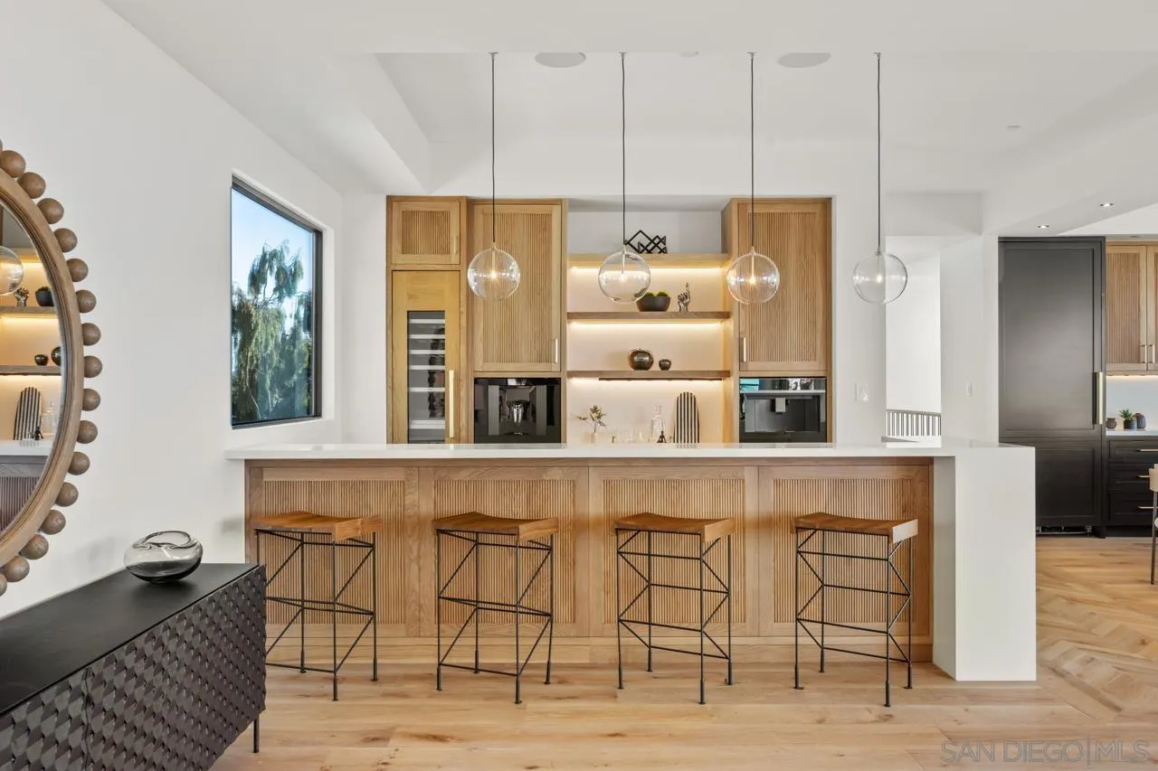 8433 Prestwick Drive La Jolla, CA 92037 - Photo 54 of 74 a kitchen with granite countertop a table chairs stove refrigerator and cabinets