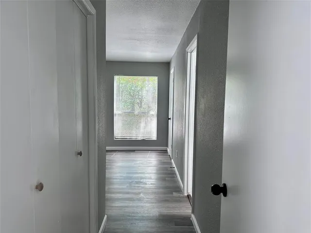 a view of a hallway with wooden floor