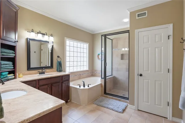 a large bathroom with a tub a double vanity sink a mirror and shower