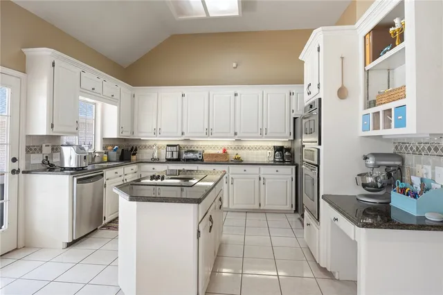 a kitchen with stainless steel appliances granite countertop a stove sink and cabinets