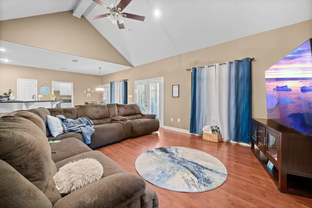 a living room with furniture and a wooden floor