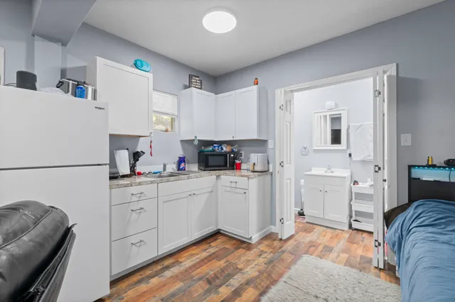 a kitchen with a refrigerator sink and cabinets