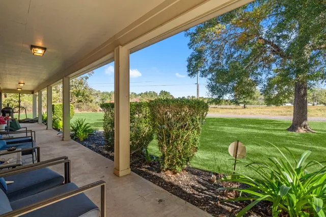 a view of a porch with furniture and garden