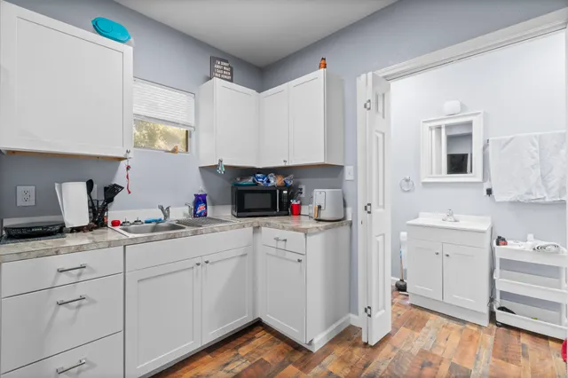 a kitchen with white cabinets and sink
