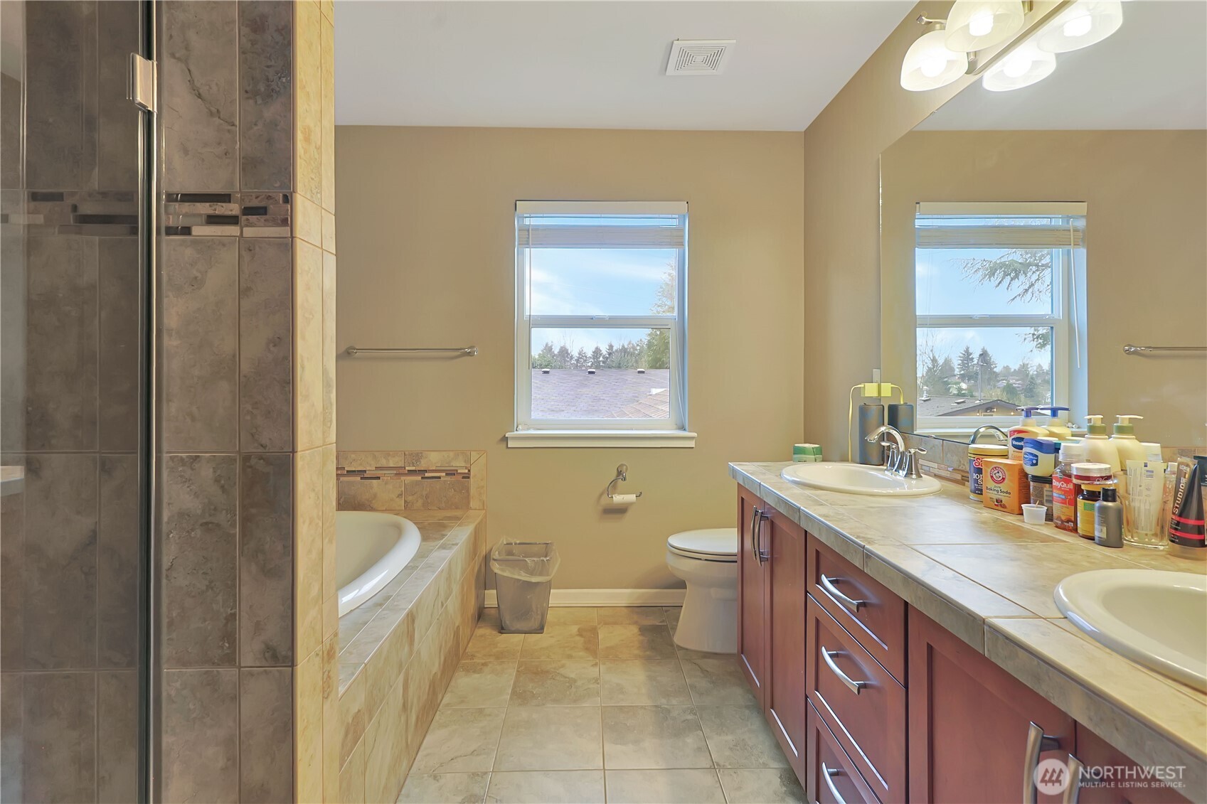 11107 Southeast 162nd Street, Unit B Renton, WA 98055 - Photo 9 of 15 a spacious bathroom with a granite countertop sink mirror vanity bathtub and a toilet