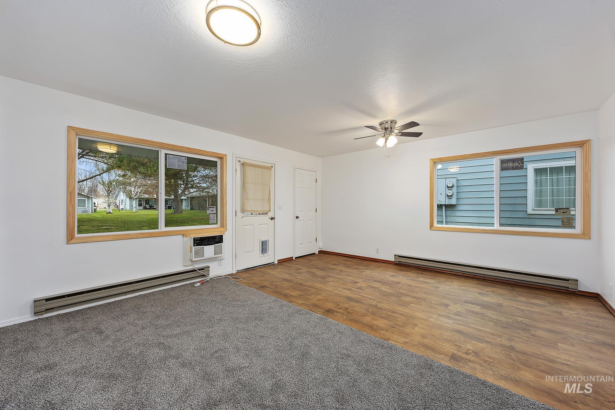 511 Union Avenue Filer, ID 83328 - Photo 4 of 25 Spare room featuring wood finished floors, baseboard heating, and ceiling fan