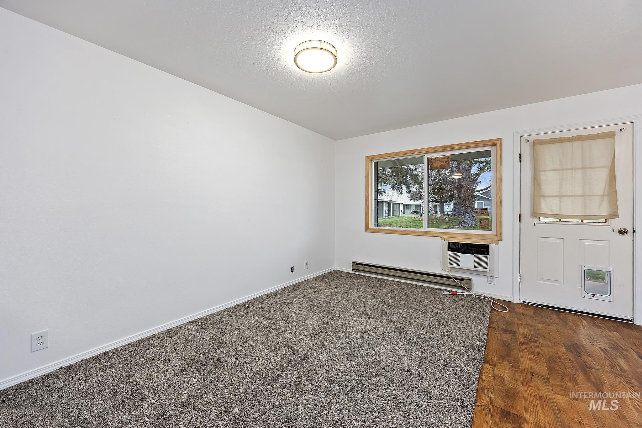 511 Union Avenue Filer, ID 83328 - Photo 6 of 25 Unfurnished room with baseboard heating, a textured ceiling, and dark wood finished floors