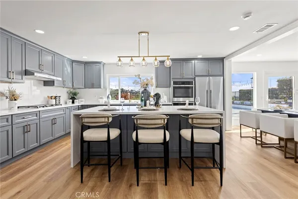 a kitchen with a table chairs refrigerator and cabinets