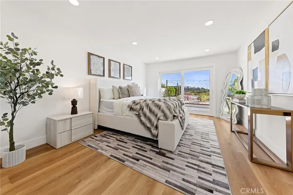 a spacious bedroom with a large bed and a potted plant