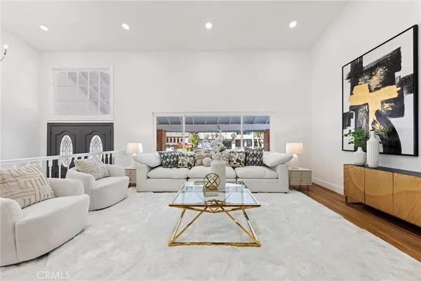 a kitchen with cabinets a sink dishwasher a dining table and chairs with wooden floor