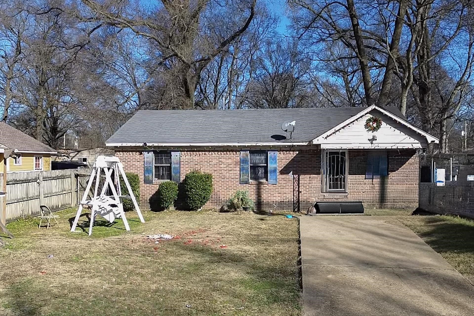 a view of a house with a yard and large tree