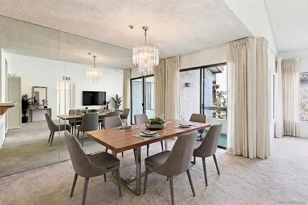 a dining room with furniture a chandelier and window
