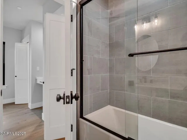 an empty room with wooden floor mirror and windows