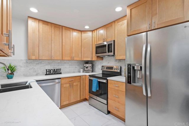a kitchen with stainless steel appliances granite countertop a refrigerator sink and microwave