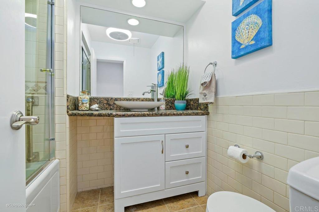 2352 Torrey Pines Road, Unit 1 La Jolla, CA 92037 - Photo 22 of 37 a bathroom with a granite countertop sink a toilet and a mirror