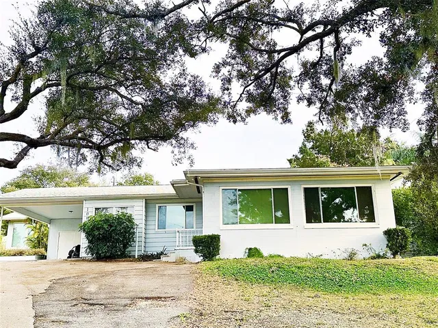a view of a house with a tree in front of it