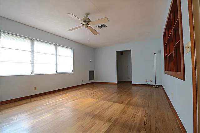 a view of an empty room window and wooden floor