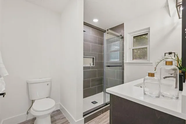 a bathroom with a sink a toilet and shower