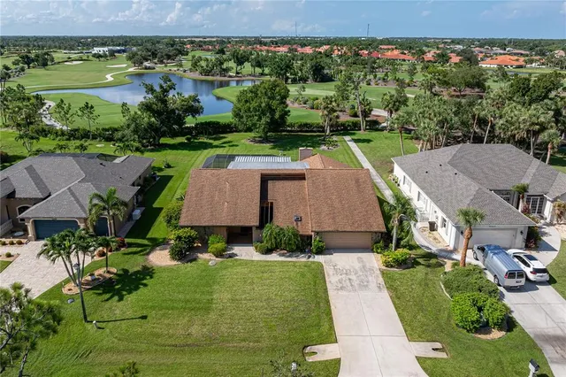 an aerial view of a house with a garden and lake view