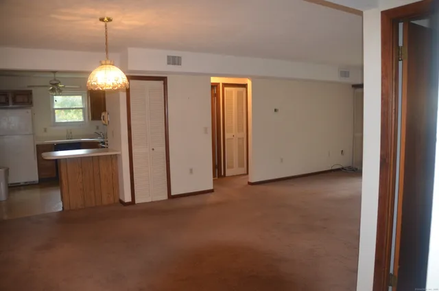 a view of a room with an entryway and chandelier fan