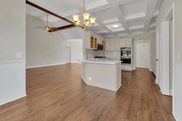 a view of a kitchen with a sink a refrigerator and cabinets